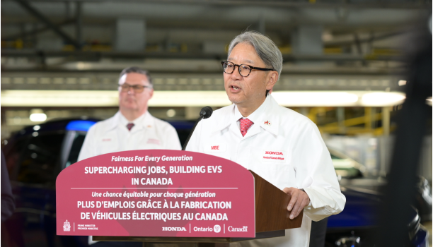 Two Honda representatives in Honda uniforms in a manufacturing plant.
