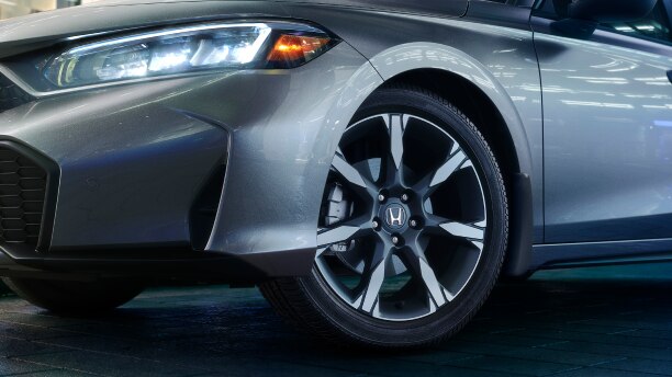 Closeup of wheel on a grey Hatchback.