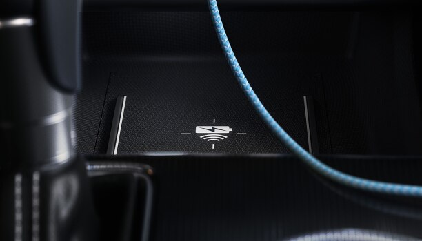 Closeup of wireless charging pad in front of gear shifter.