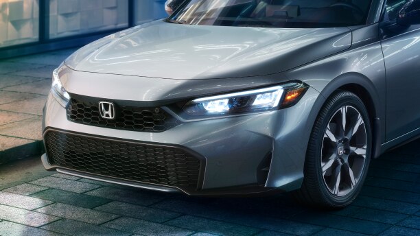 Closeup of headlights on a grey Hatchback.