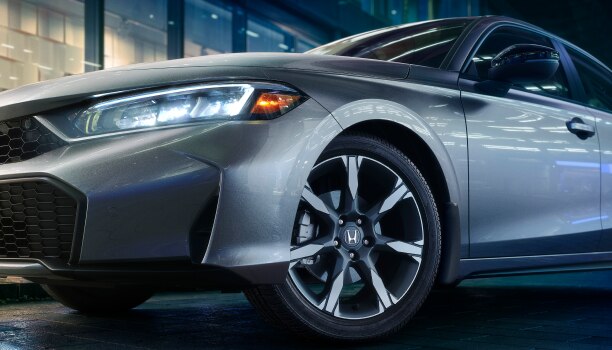 Closeup of wheel on a grey Hatchback.