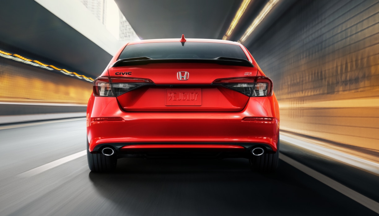 Rearview of red Civic Si driving in tunnel.