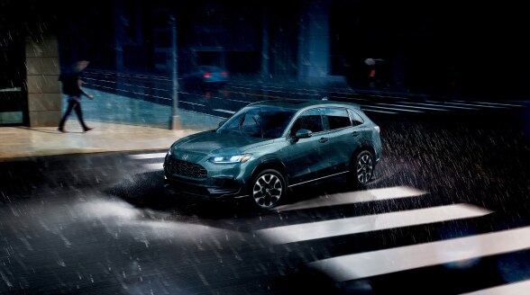 3/4 rear view of grey HR-V driving at night. 