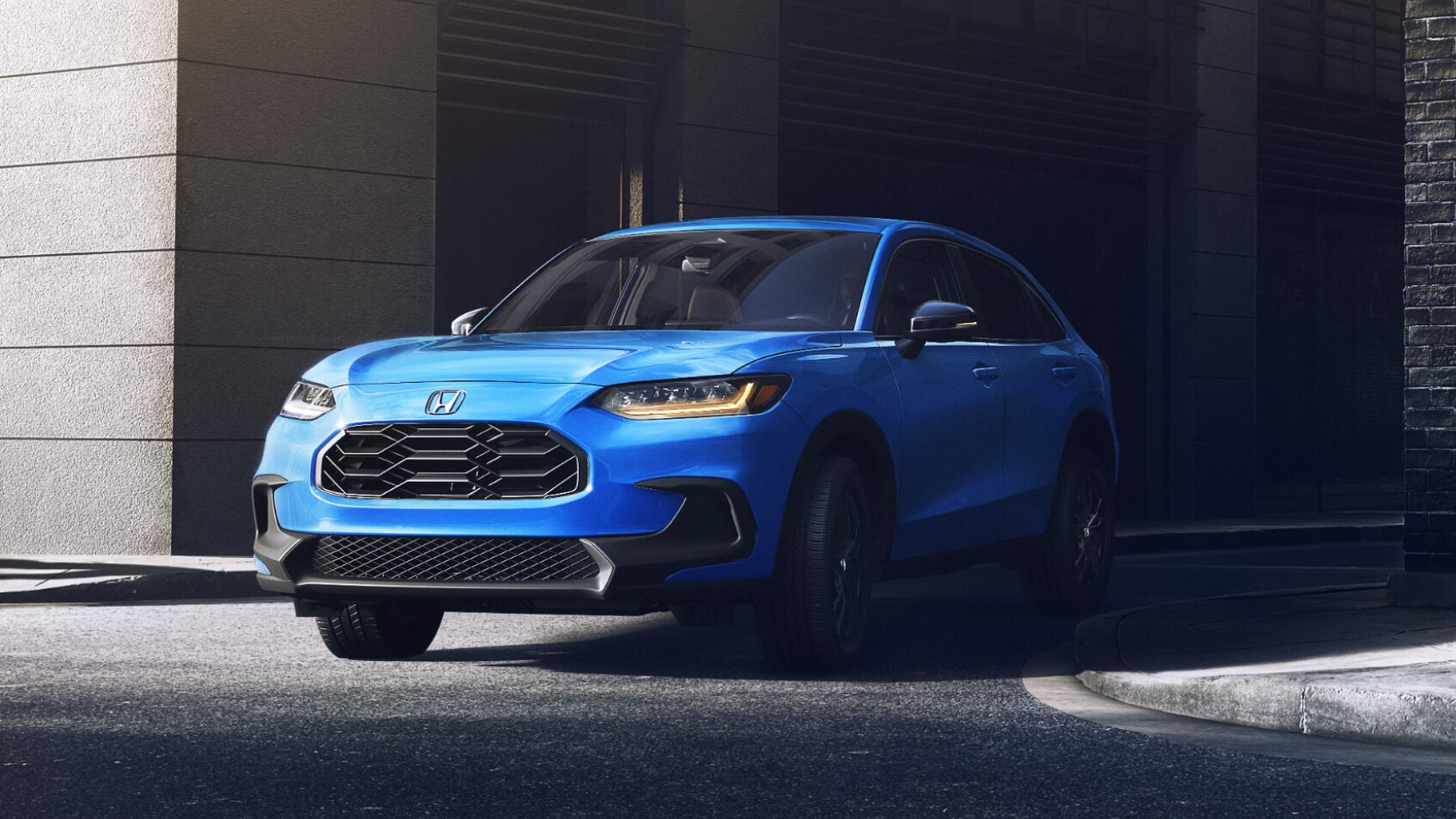 3/4 front view of blue HR-V pulling out of an alleyway in the city.