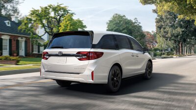 3/4 rear view of white Odyssey braking in suburban street.