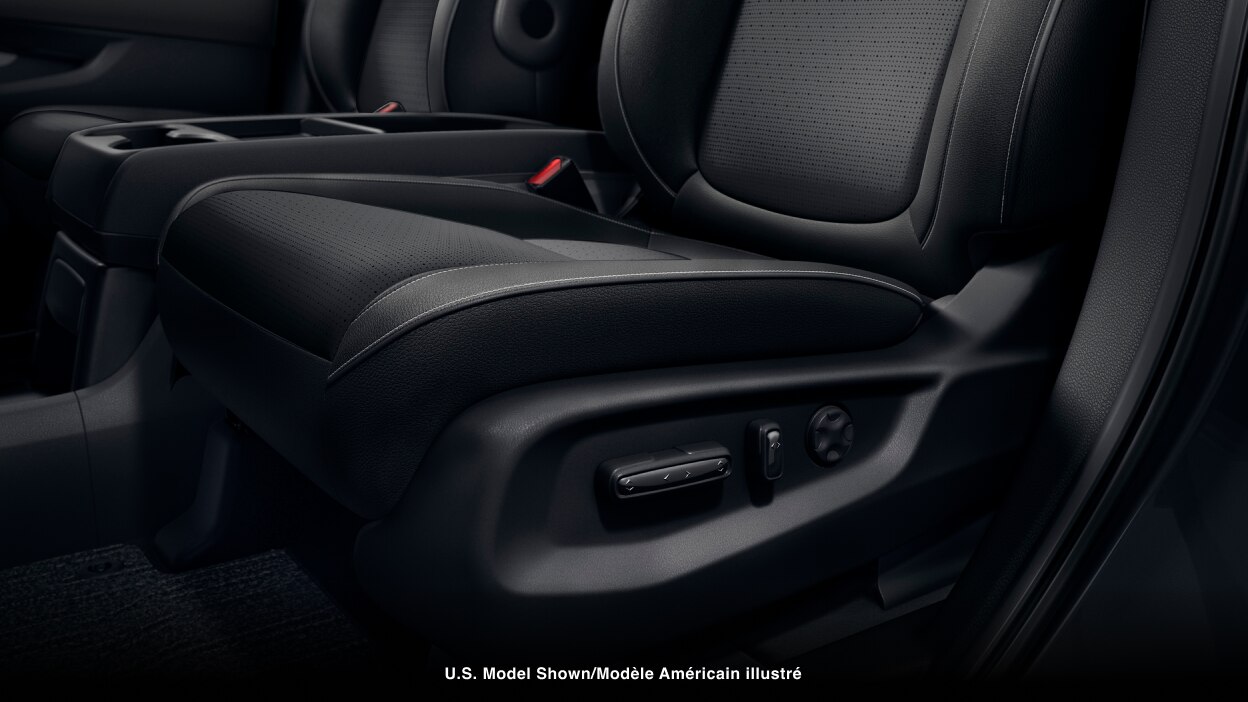 Closeup of power adjustment buttons on the side of a seat.