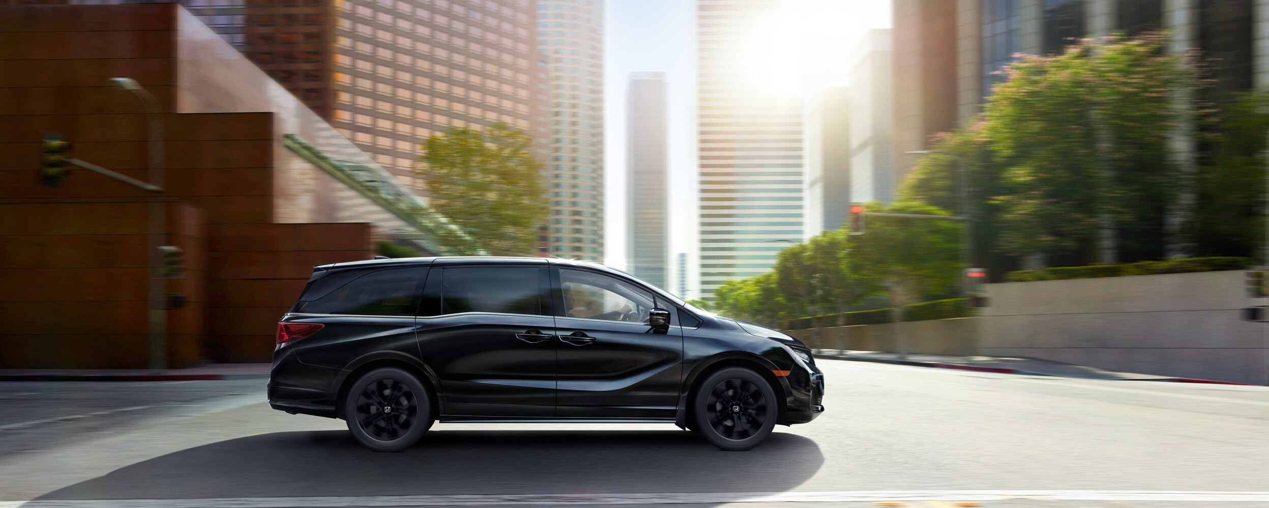 Side front view of black Odyssey driving in city.