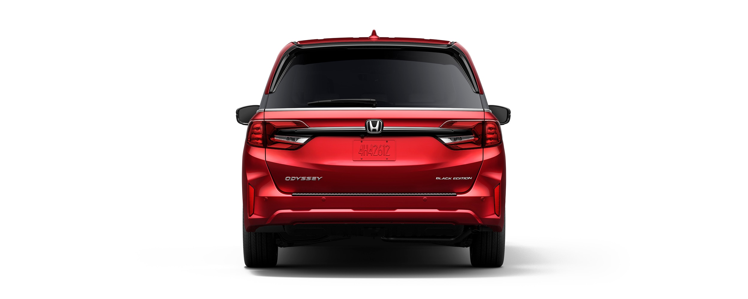 Wide rear view of red Odyssey on white space.