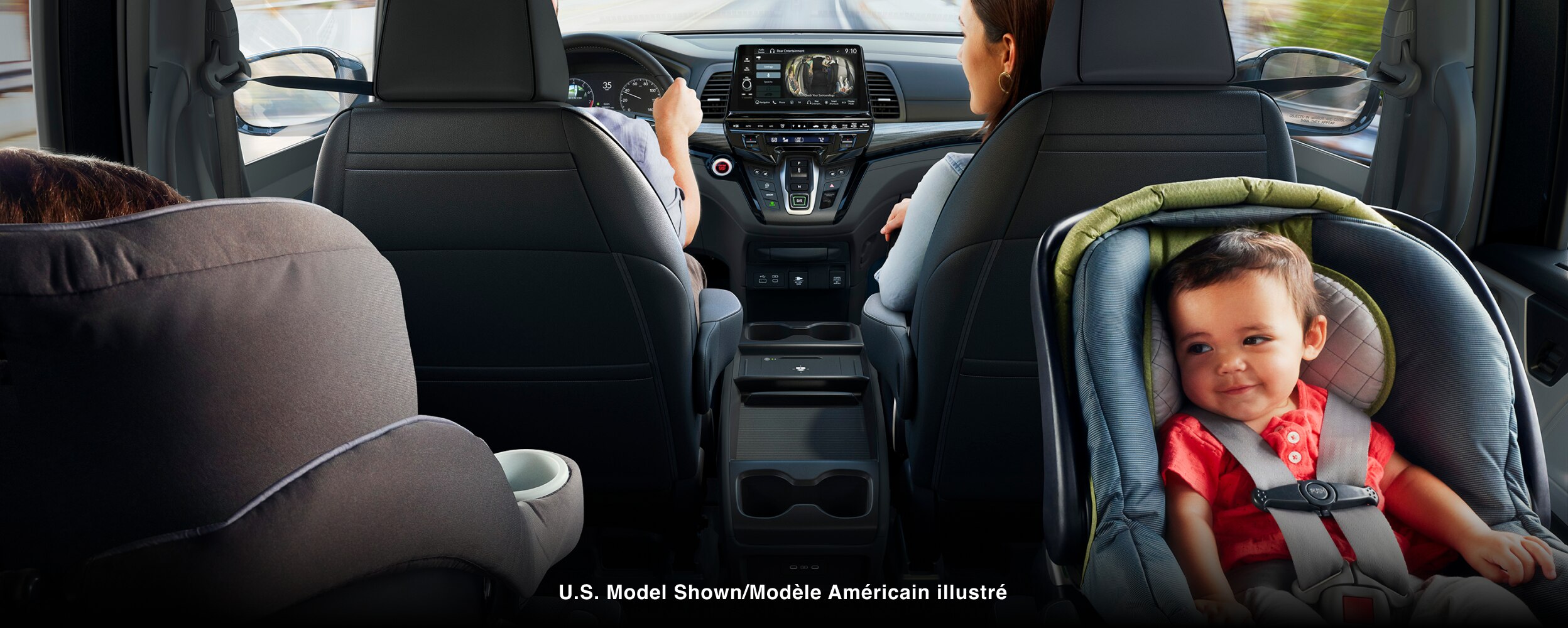 Interior view of Odyssey. Dad driving; Mom in front passenger seat; kid in car seat.