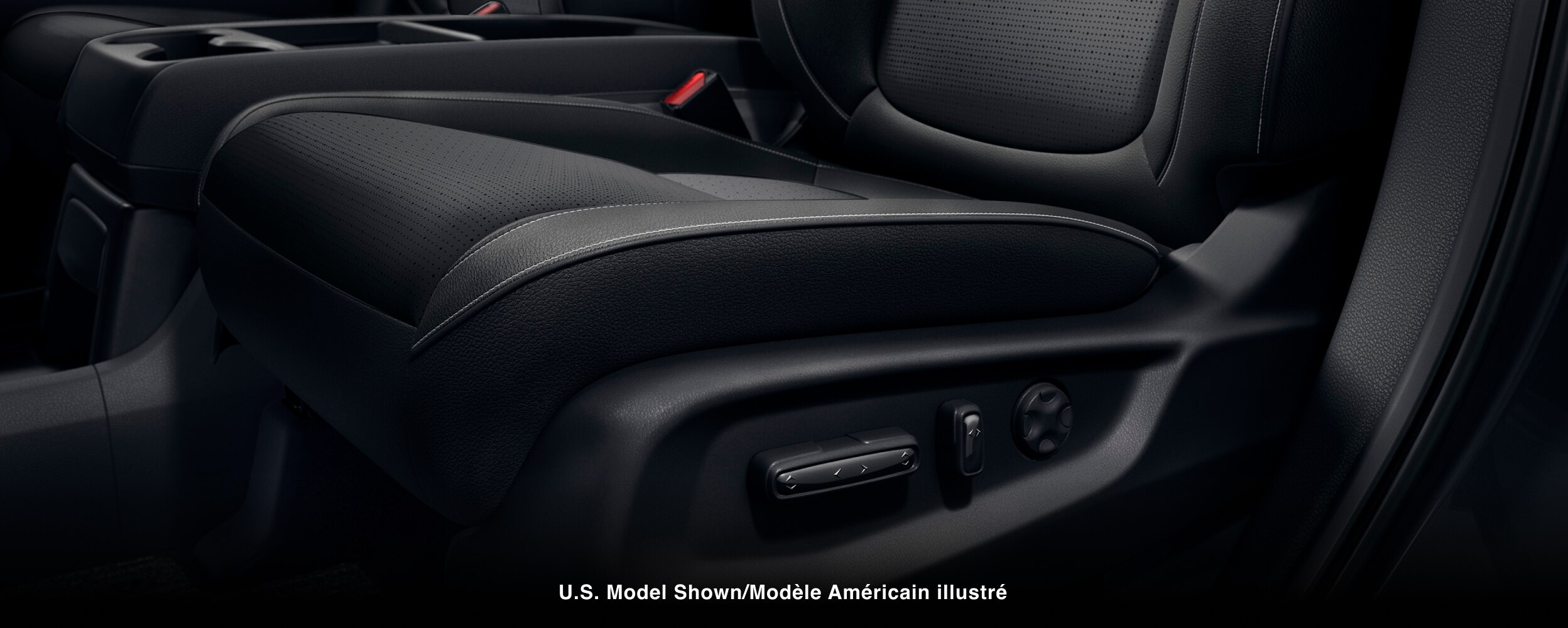 Closeup of power adjustment buttons on the side of a seat.