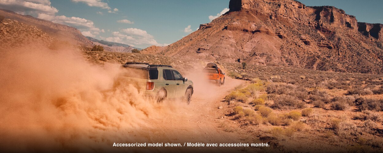 A grey Passport drives through dusty desert terrain. 