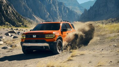 Front view of a Passport is shown driving through rugged terrain. 