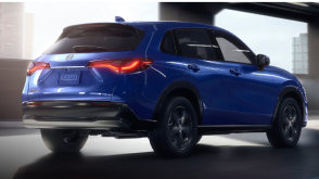 3/4 rear view of blue HR-V driving in empty parking garage.